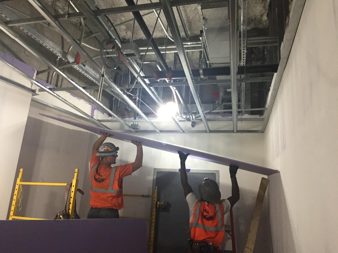 Sheetrock ceiling installation in a commercial office buildout